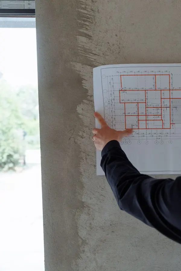 Ingeniero con casco revisando un plano en la obra