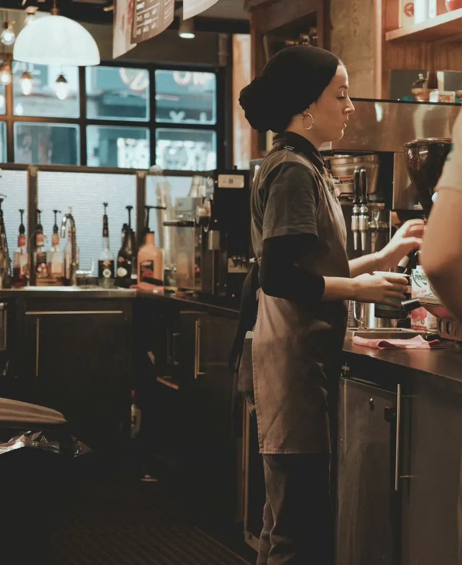 Barista preparando café detrás de la barra