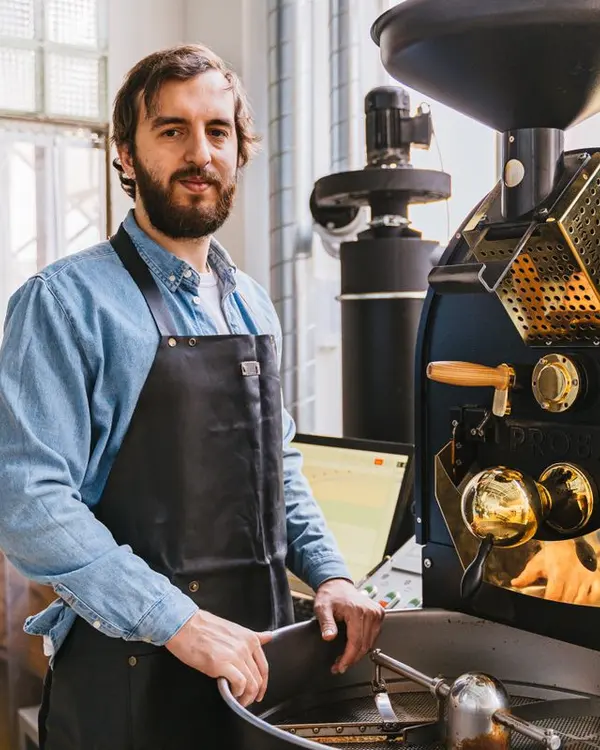 Rodrigo Benítez, barista y tostador, junto a la tostadora de café