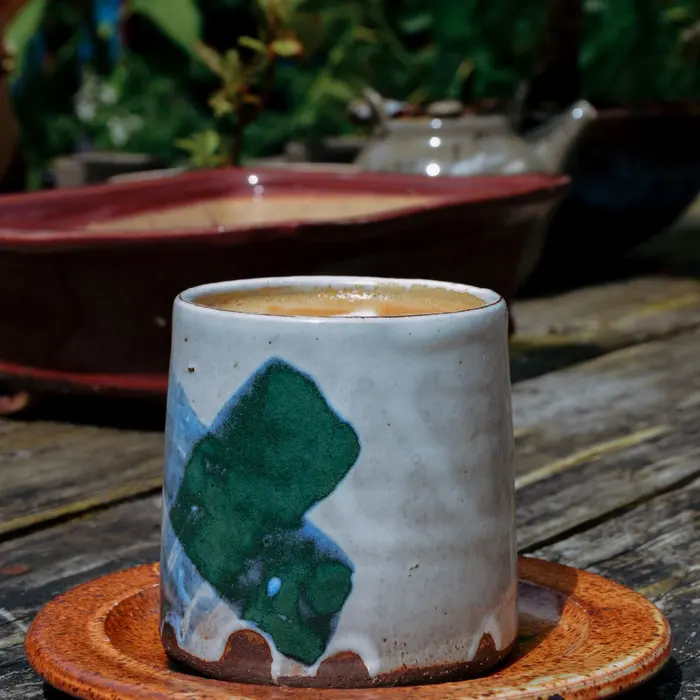 Taza de cerámica artesanal sobre la mesa de madera