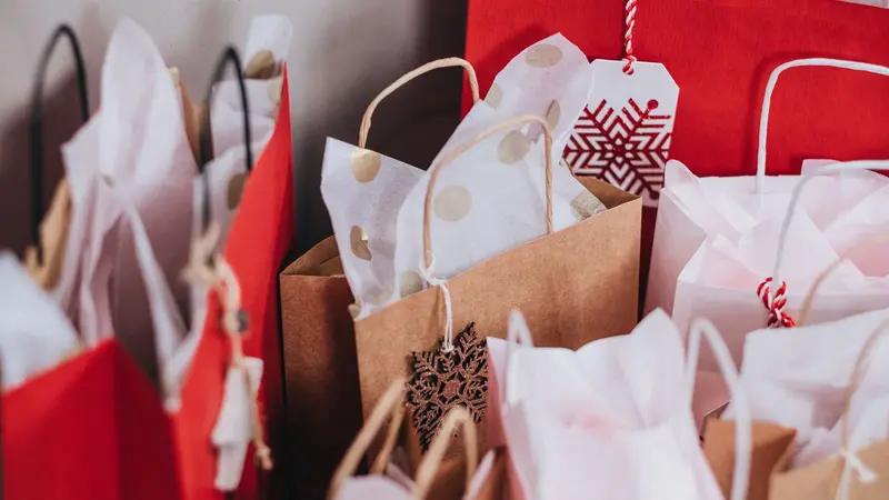 Bolsas de regalo de papel, rojas, blancas y marrones, con etiquetas navideñas