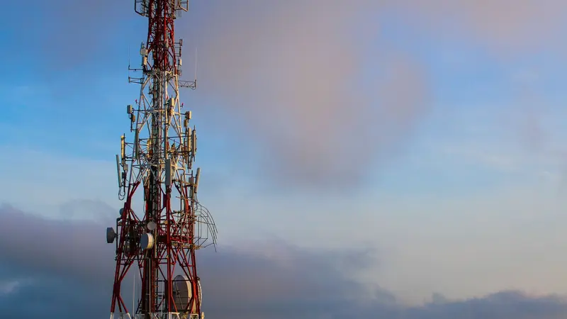 Torre de telecomunicaciones recortada contra el cielo al atardecer