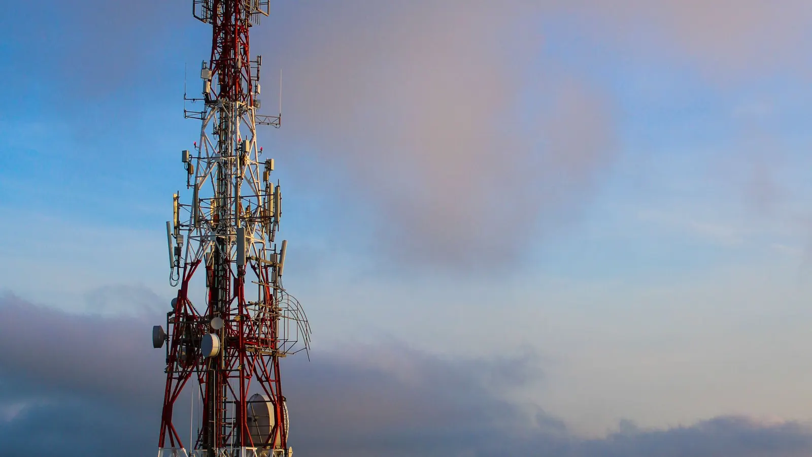 Torre de telecomunicaciones recortada contra el cielo al atardecer