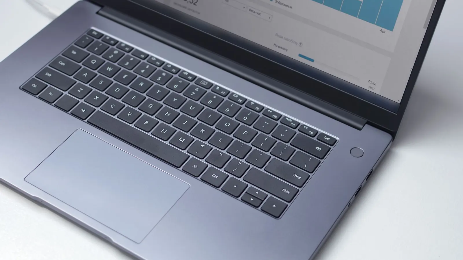 Persona analizando gráficos de estadísticas en la pantalla de una laptop
