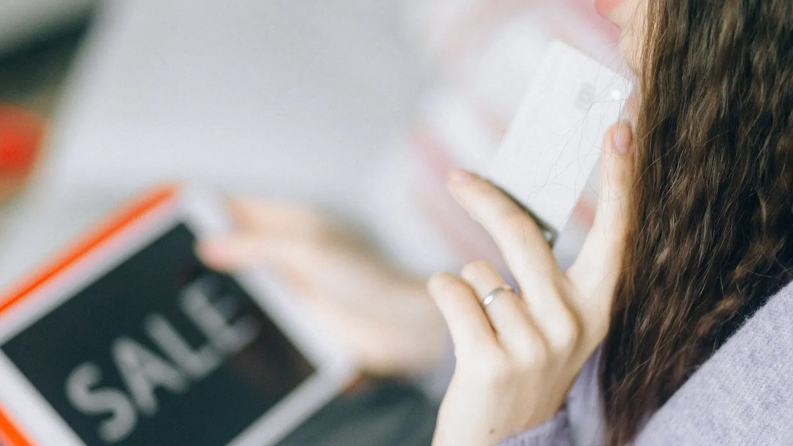 Mujer sosteniendo una tarjeta y una tablet, comprando online