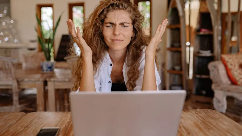 Mujer frustrada frente a la laptop trabajando