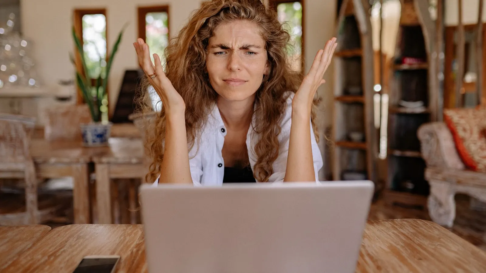 Mujer frustrada frente a la laptop trabajando