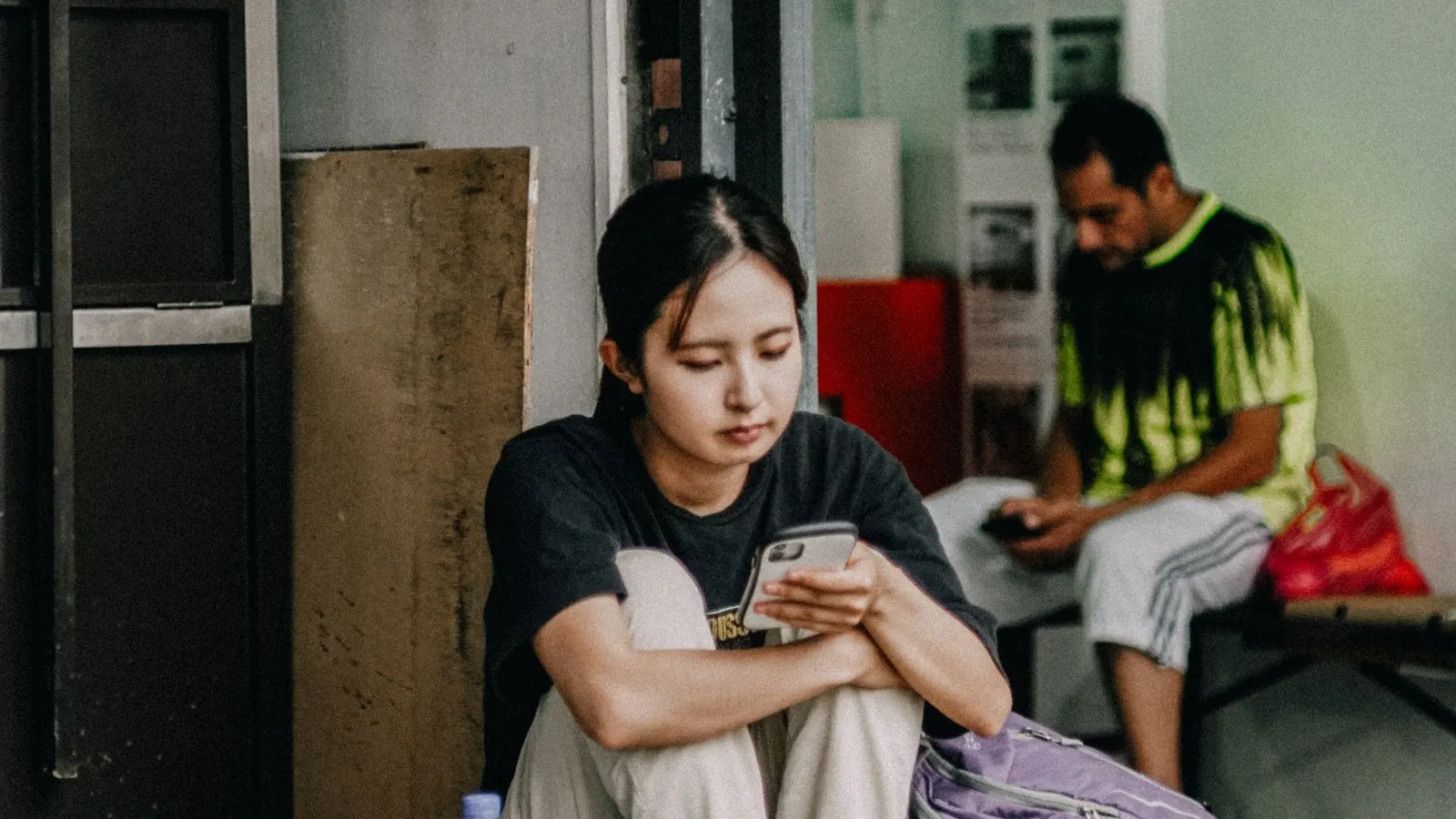 Joven esperando mientras mira su celular