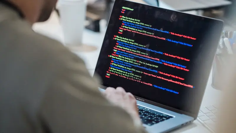 Programador enfocado trabajando en su laptop en una oficina