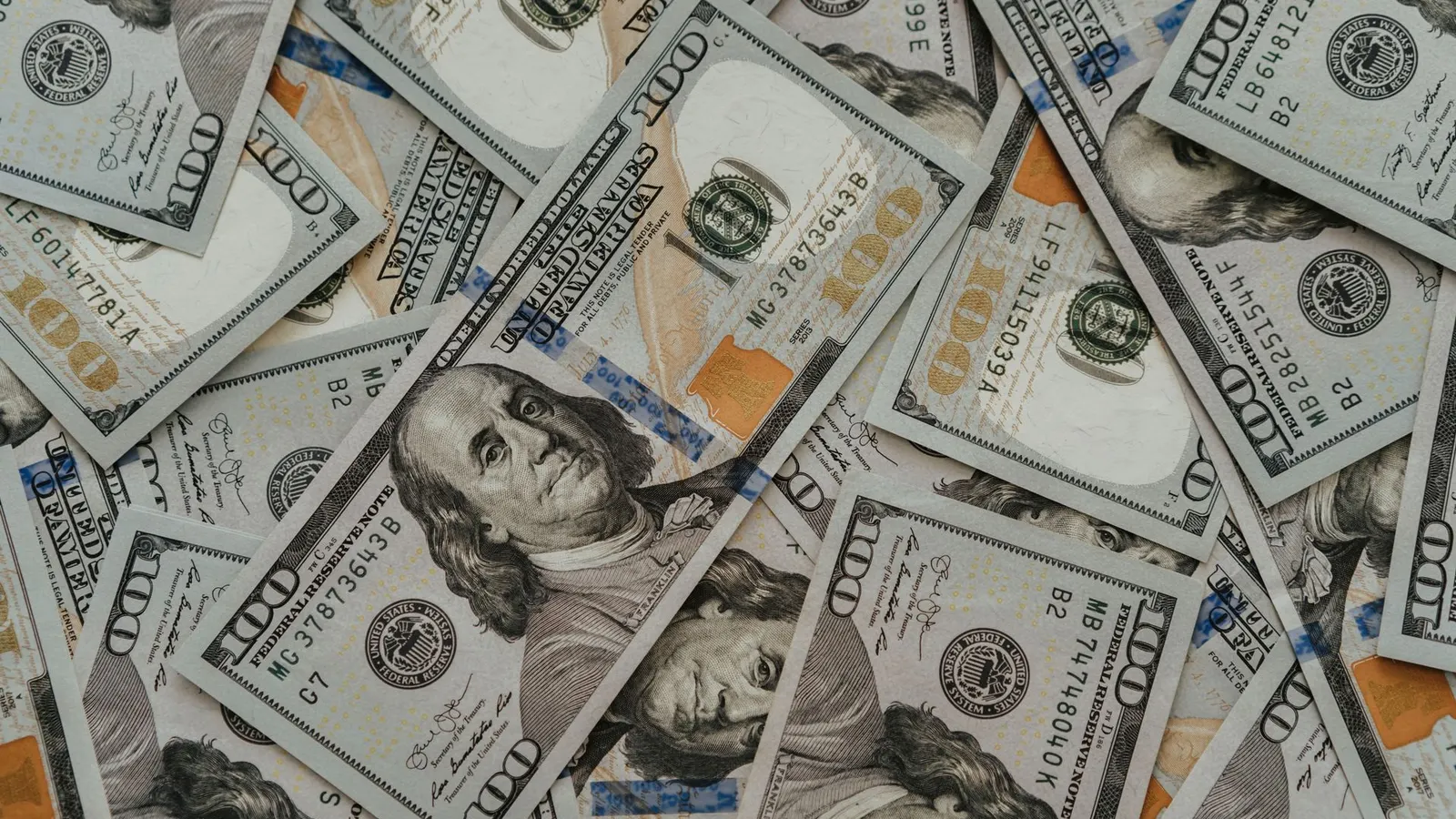Persona contando billetes de dólar sobre un escritorio