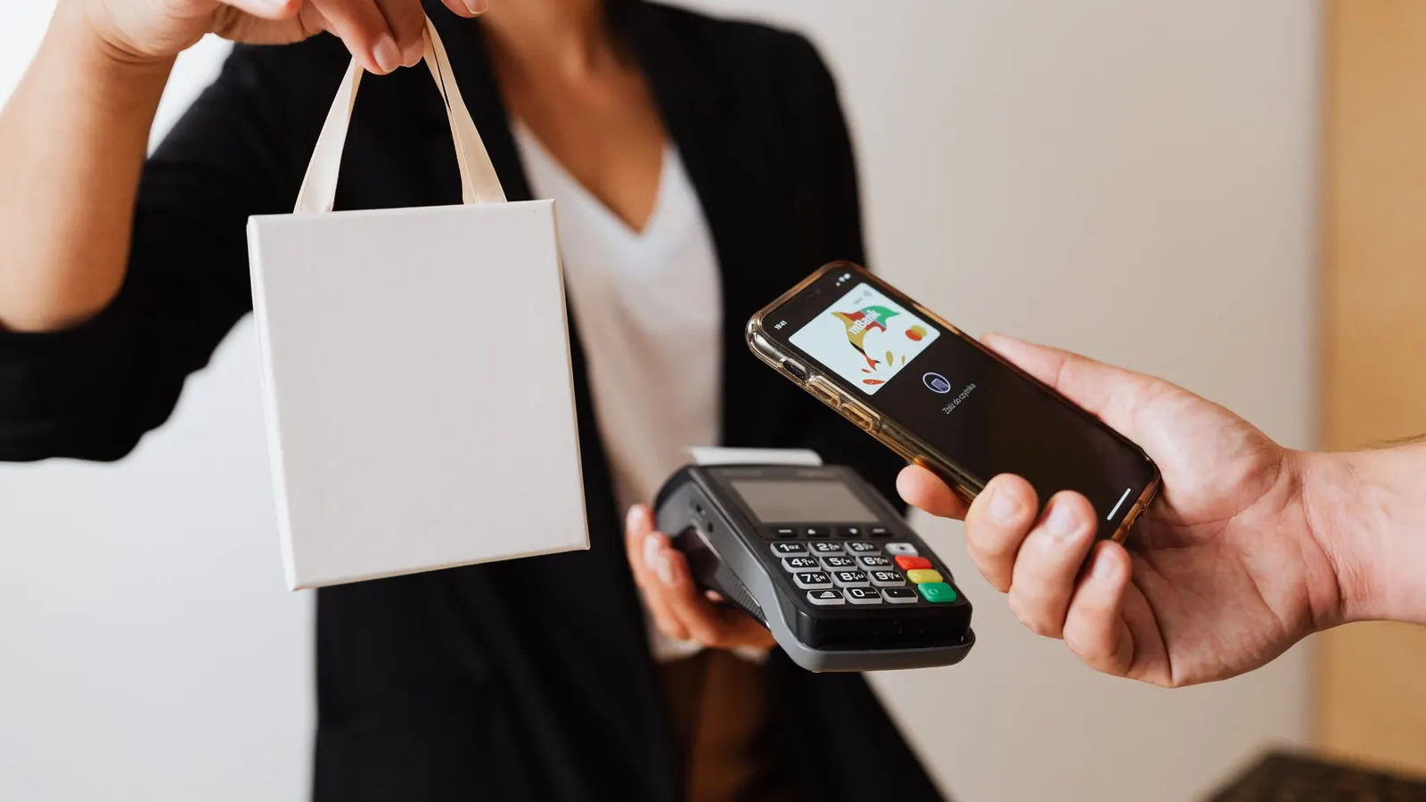 Persona pagando con billetera digital y código QR desde su celular en un comercio