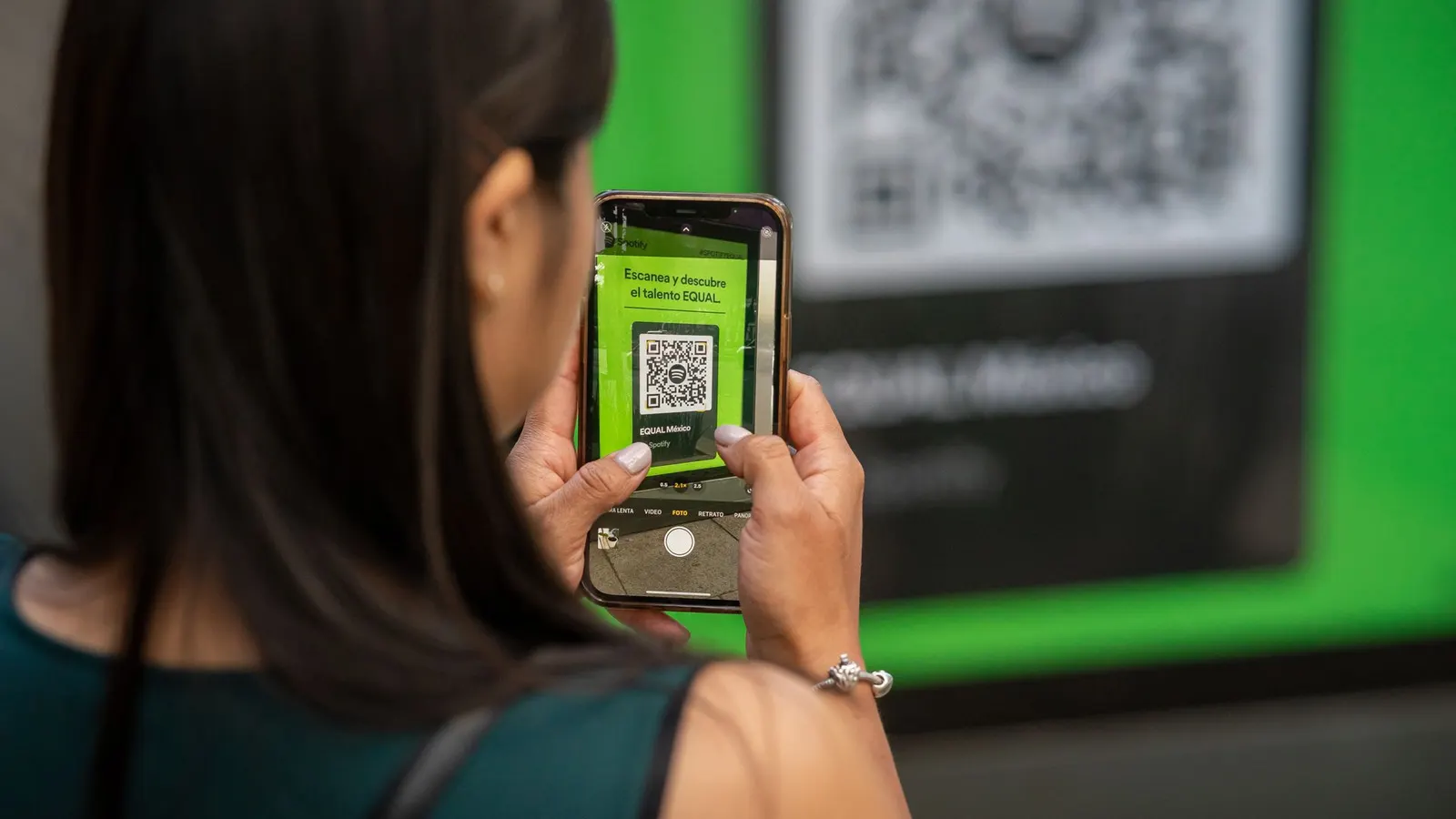 Mujer escaneando un código QR con la cámara de su celular