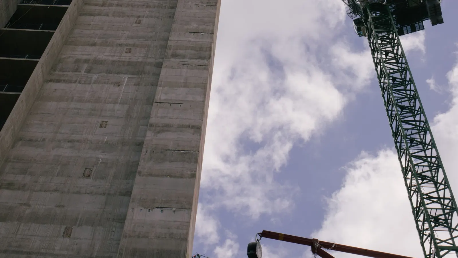 Guindaste de construção trabalhando ao lado de um prédio moderno