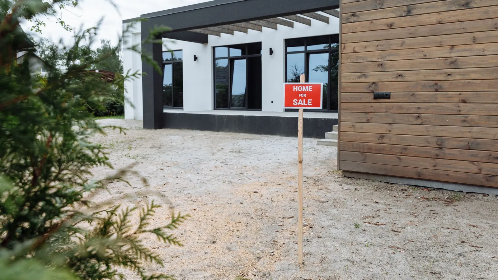 Casa moderna com placa de venda no jardim da frente