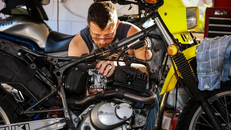 Mecánico reparando el motor de una motocicleta en un taller