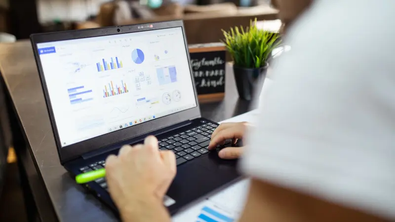 Persona analizando gráficos y datos de mercado en la pantalla de una computadora