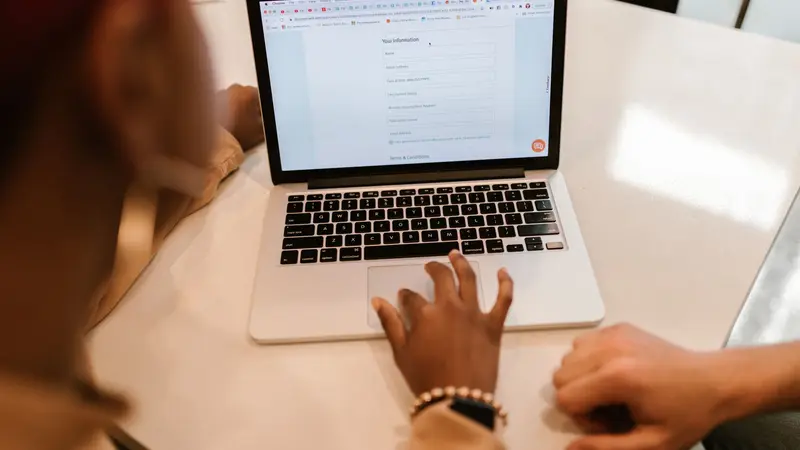 Persona completando un trámite en línea desde una notebook en una oficina pública