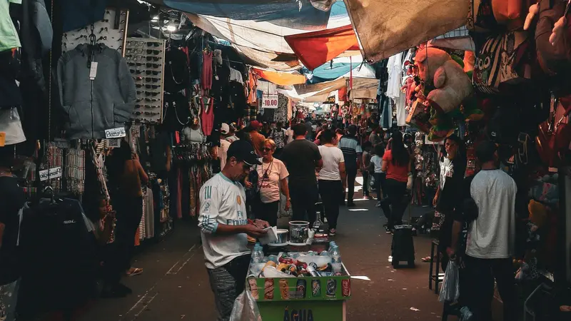 Vista de una calle comercial concurrida con locales y compradores