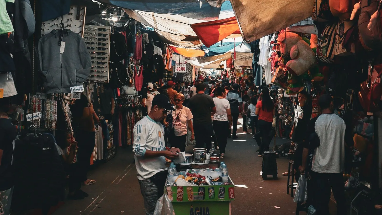 Vista de una calle comercial concurrida con locales y compradores
