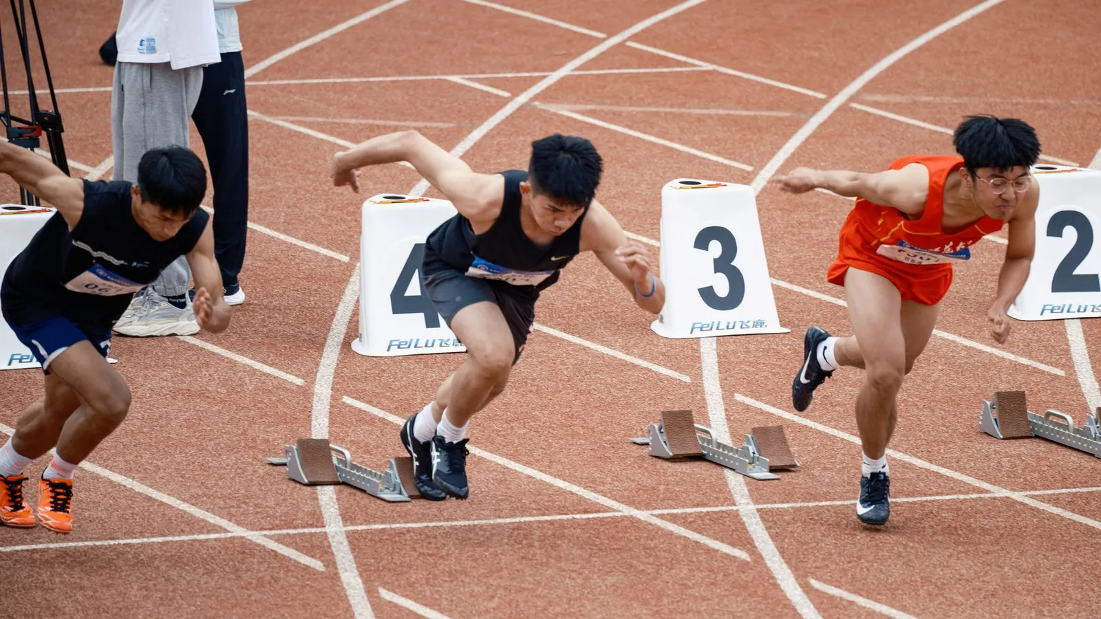 Corredor arrancando desde los tacos de salida en una pista de atletismo