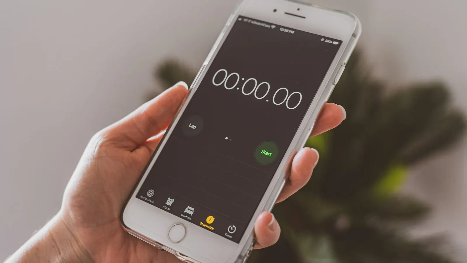 Una mano sostiene un celular con el cronómetro en cero, a punto de empezar a contar