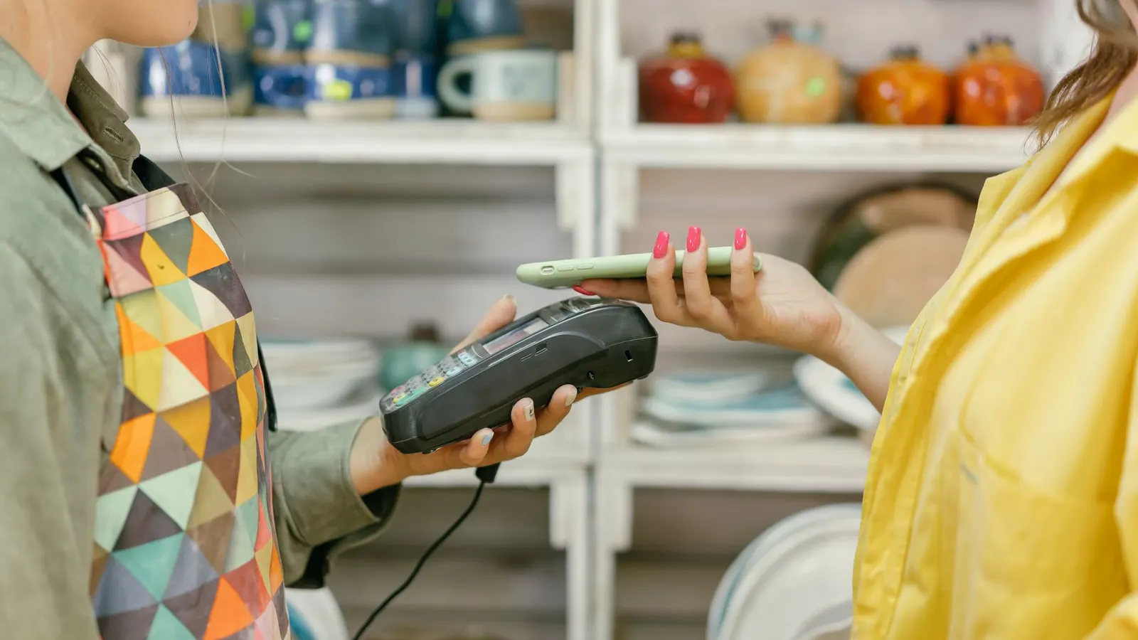 Cliente pagando con el celular en el mostrador de un comercio